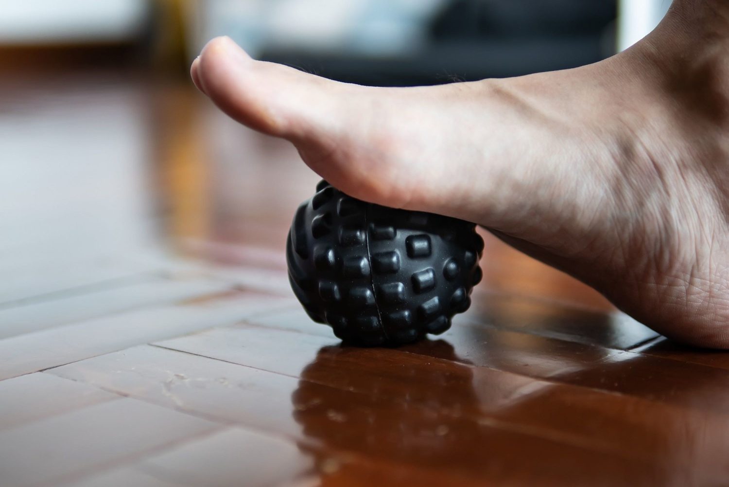 pessoa com os pés na bolinha de tratamento para fascite plantar