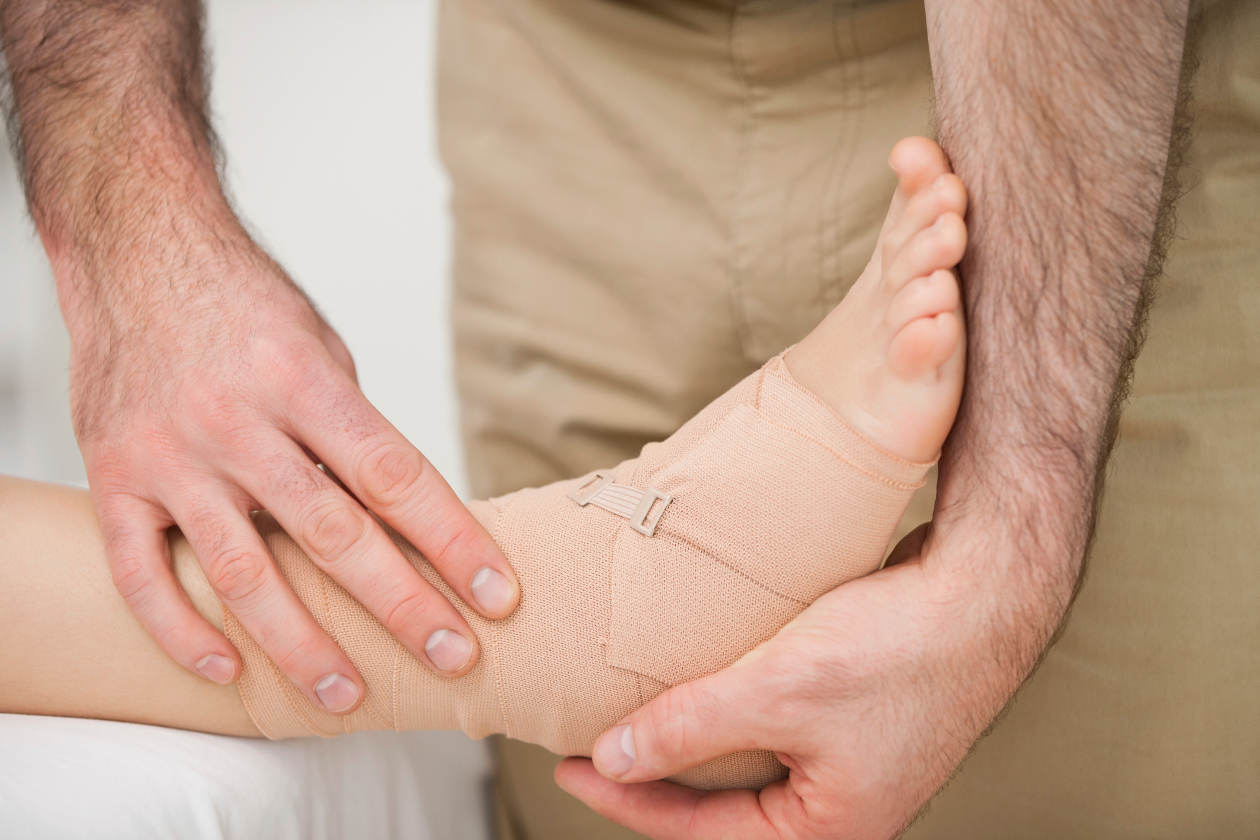 profissional segurando um dos pés da paciente com bandagem para má circulação nos pés 