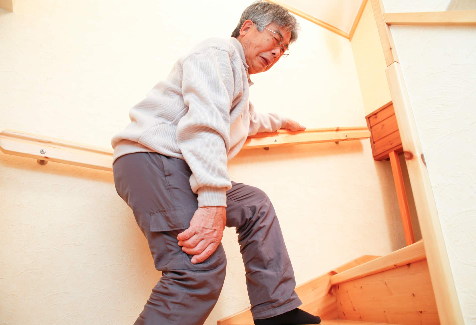 homem idoso com artrite e gonalgia ao subir escadas